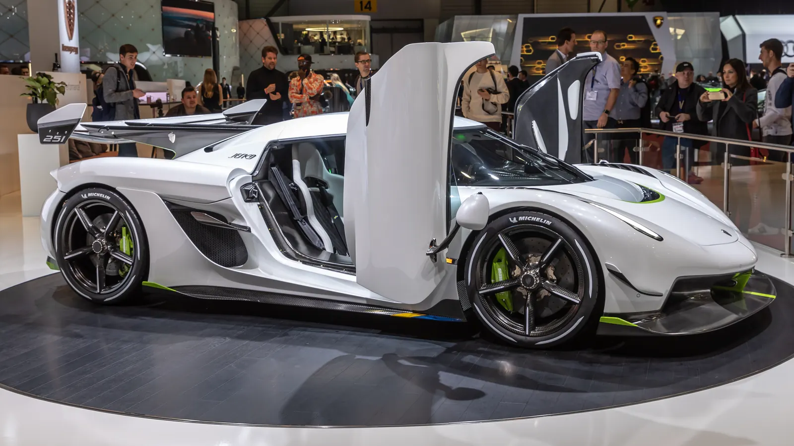 White Koenigsegg Jesko supercar with its doors open on display at an auto show