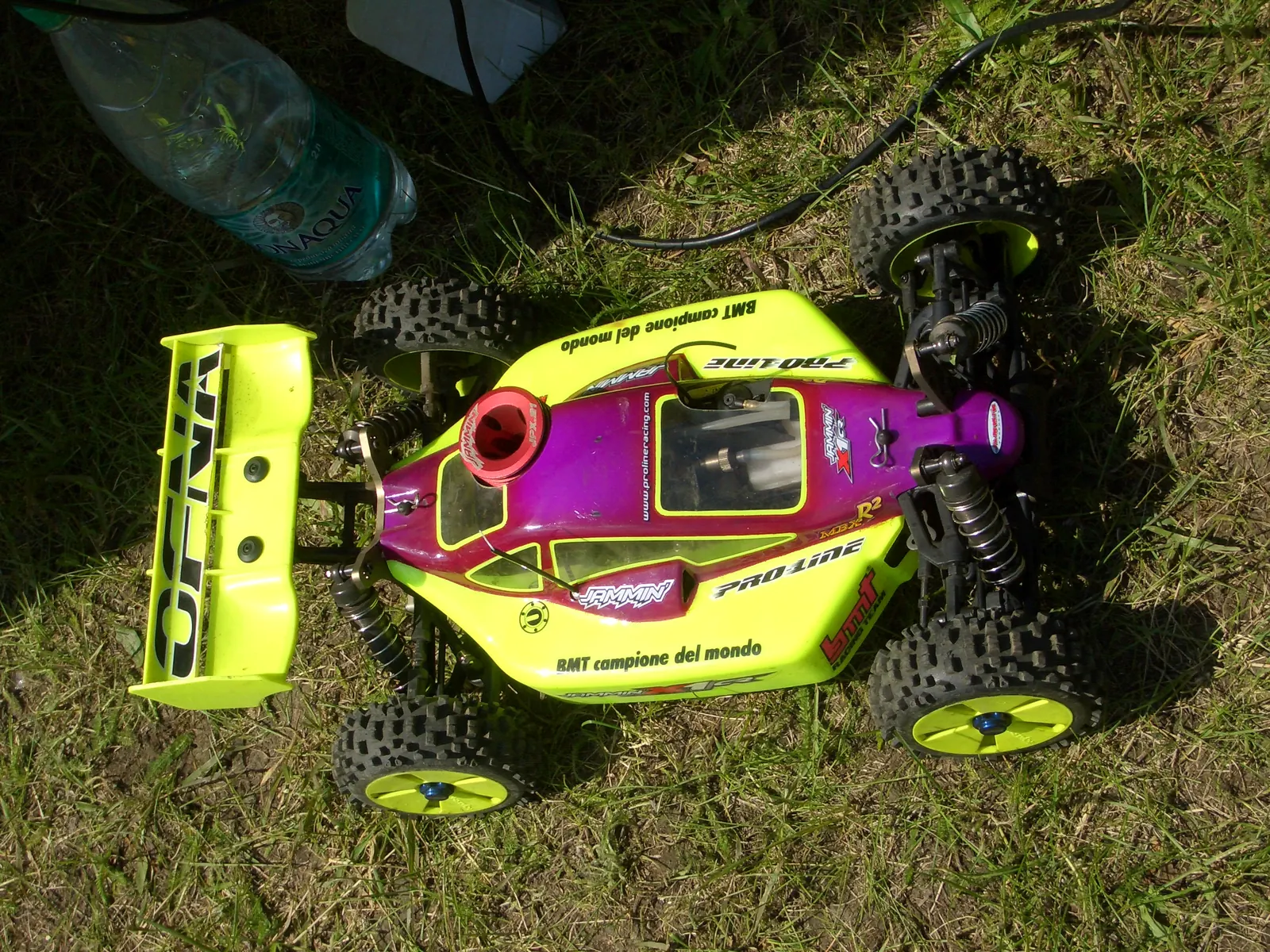 OFNA nitro RC buggy with a yellow and purple body on the grass