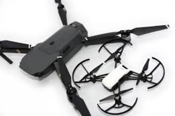 White DJI Tello mini drone next to the folded arms of a larger gray DJI drone