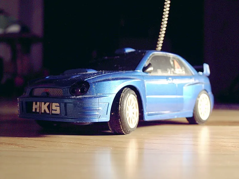RC car with a painted blue Subaru Impreza body and decals
