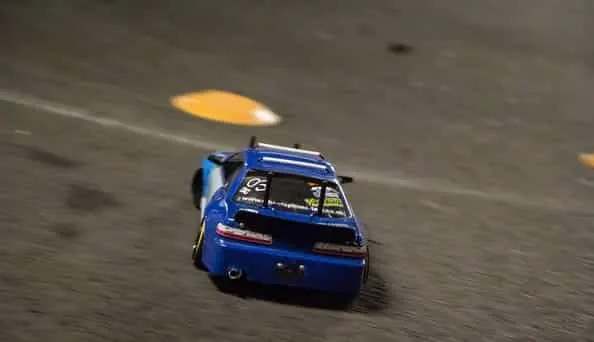 Blue RC drift car sliding sideways on a track