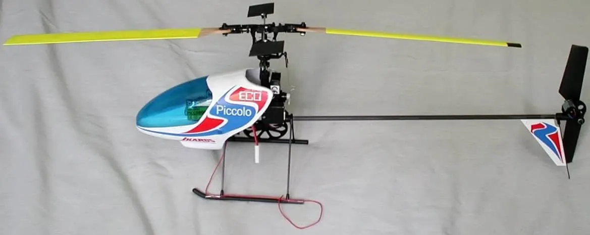 Ikarus Piccolo electric RC helicopter with a white and blue canopy and yellow blades