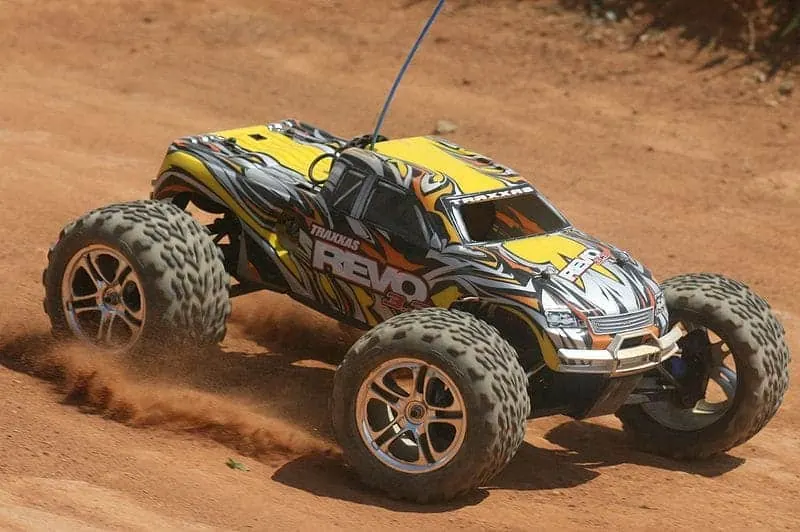 Yellow Traxxas Revo monster truck kicking up dirt