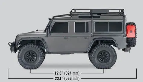 Side view of a gray Traxxas TRX-4 Defender with its wheelbase and overall length marked in inches and millimeters