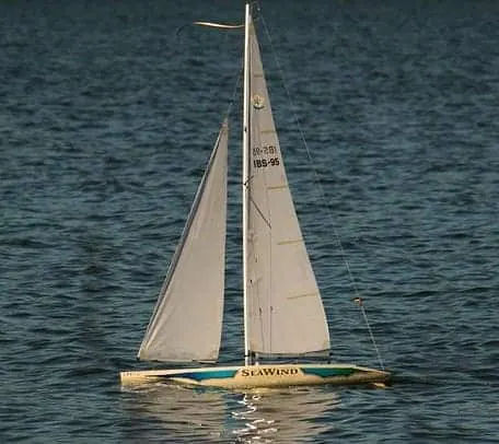RC sailboat with two white sails on the water