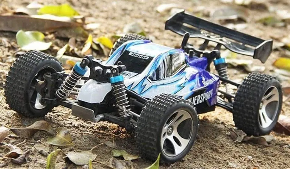 WLtoys A959 RC buggy with a blue and white body and rear wing on a dirt surface