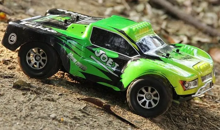 WLtoys A969 RC short course truck with a green body on a dirt trail